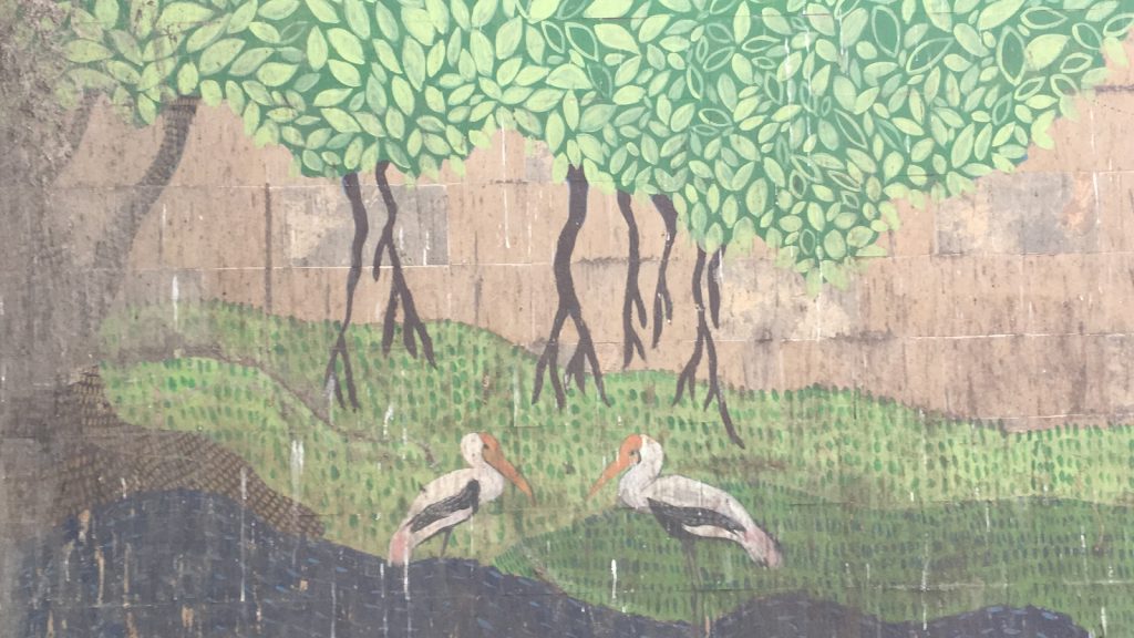 A painted mural of two storks in the riverside.