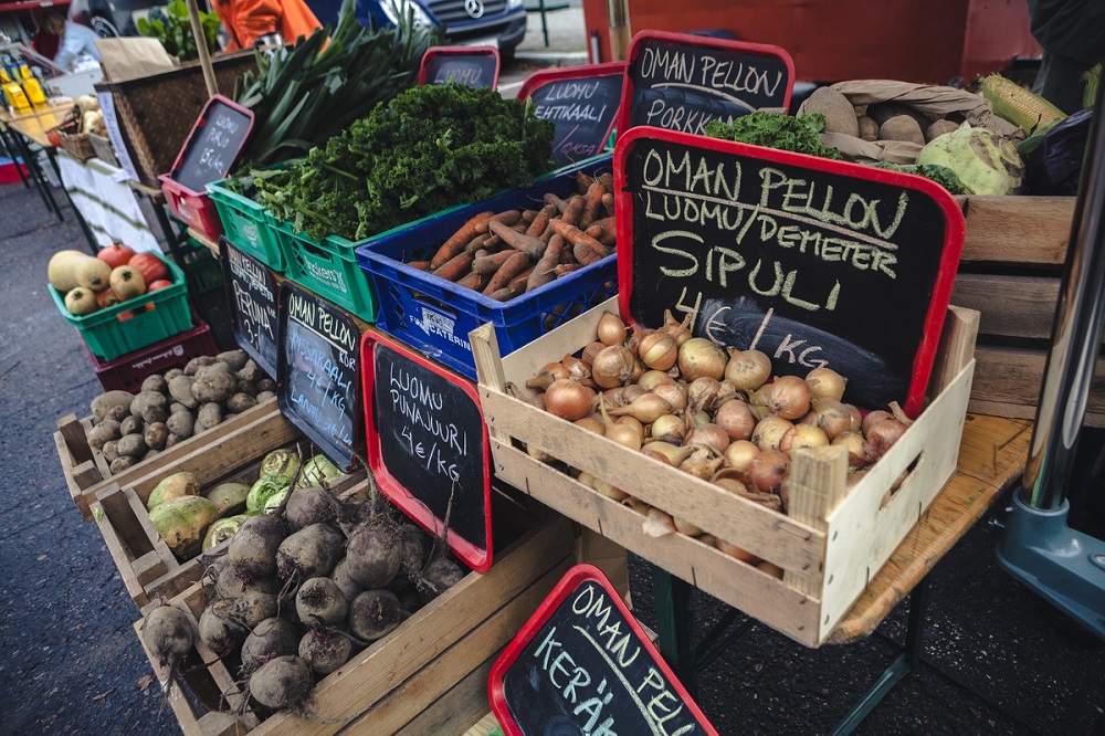 Paikallisen elintarviketuotannon tarjottavia on näkyvissä torikojun tiskillä, jossa myynnissä on muun muassa perunaa ja porkkanaa.