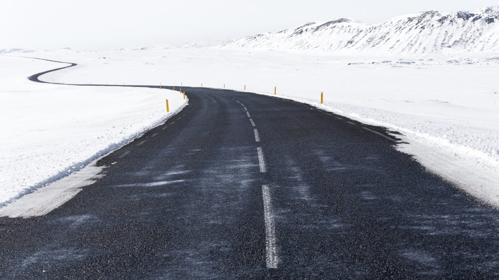 Luminen maisema, jossa on tumma asfalttitie. Arktinen ympäristönsuojelustrategia.