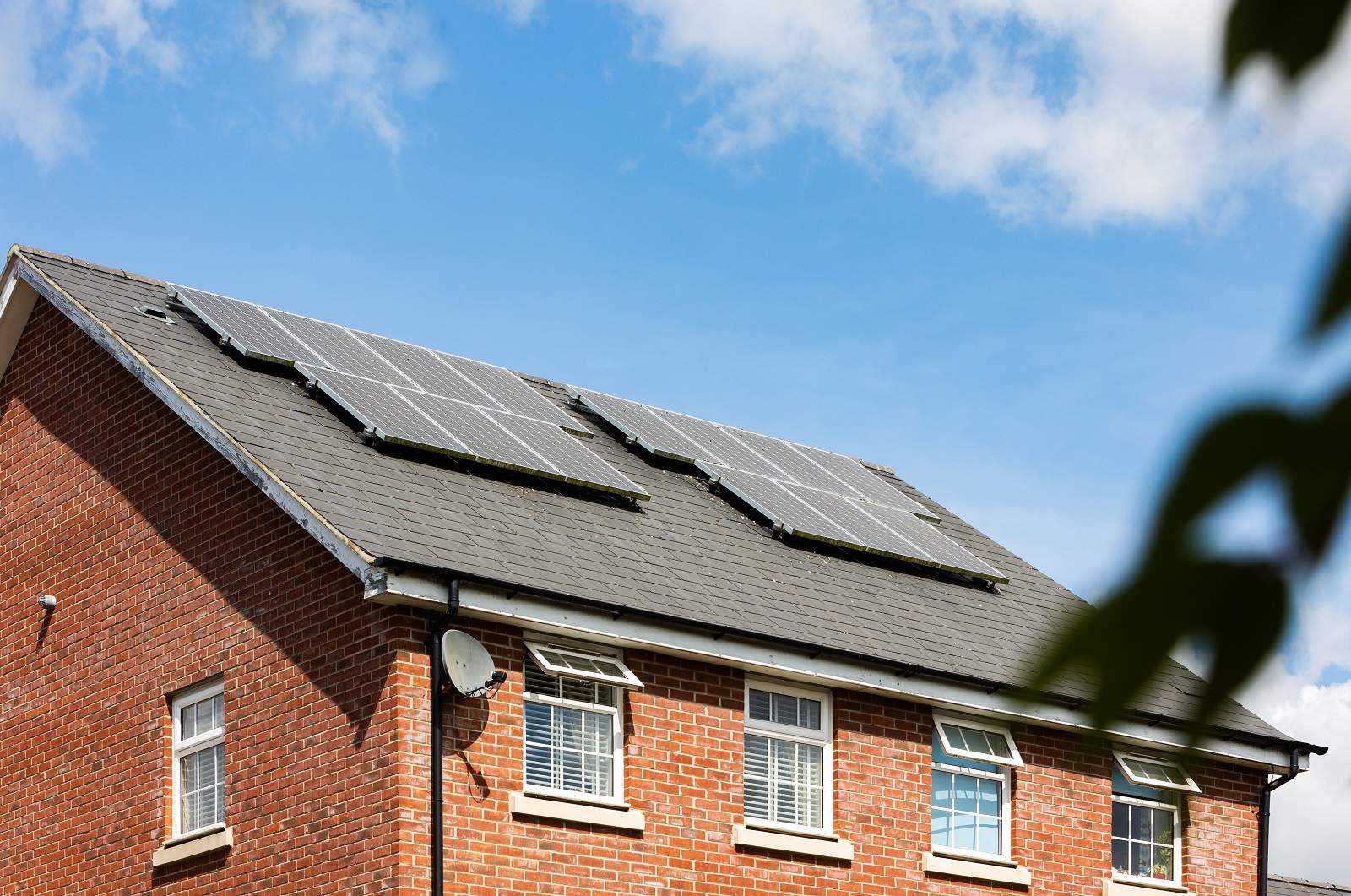Paikallisyhteisöt ovat edistäneet aurinkopaneelien käyttöä. Kuvassa omakotitalo, jonka katolla on aurinkokeräimiä.